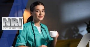 a female nurse in scrubs sipping coffee