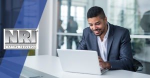well dressed male in front of a laptop
