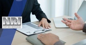 close up of a resume and someone gesturing at an interview
