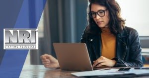 woman with glasses looking at a laptop