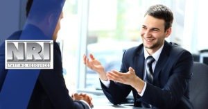 young man in a suit smiling ans gesturing in his interview
